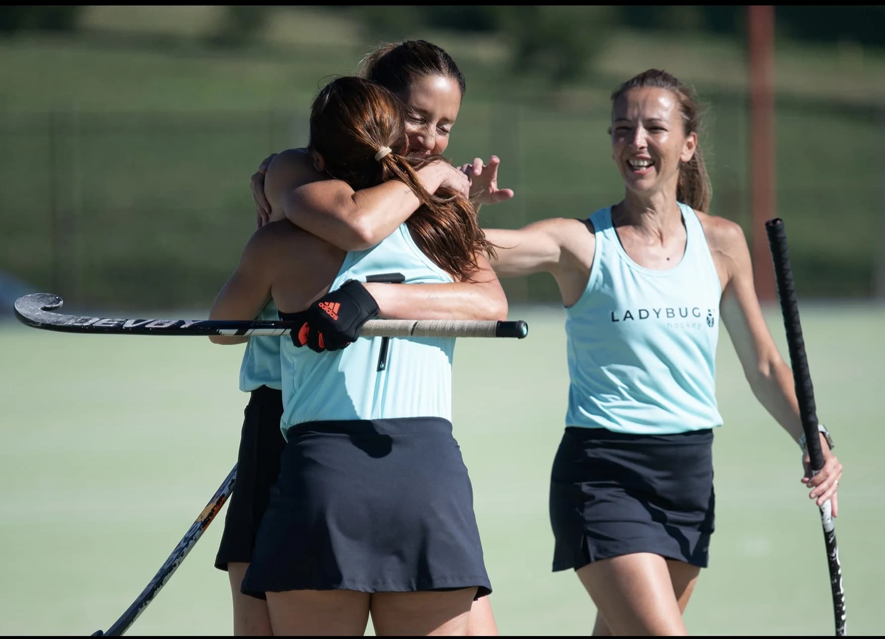 Dos jugadoras con uniformes Ladybug en un partido de hockey