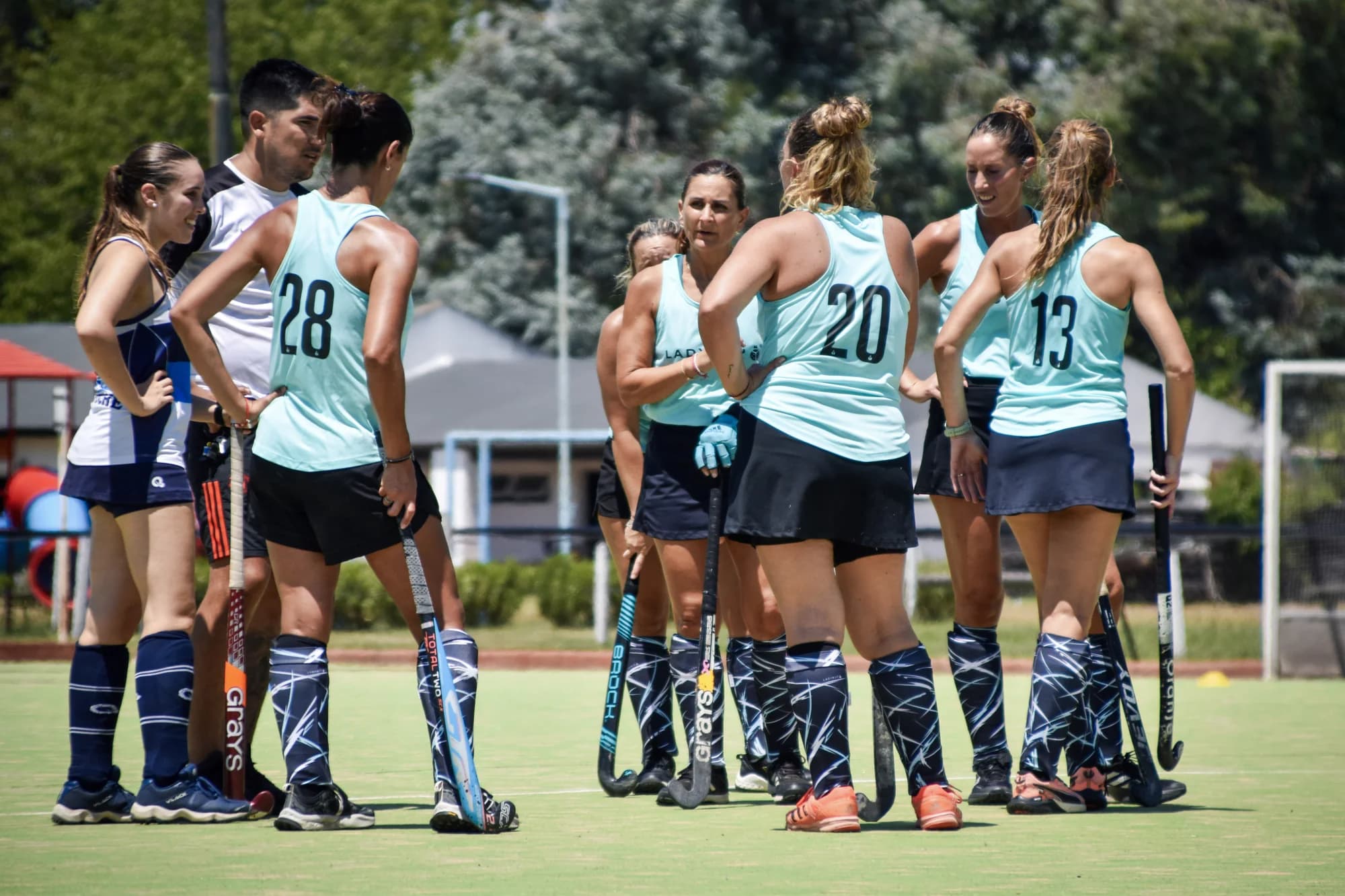 Equipo con camisetas turquesas Ladybug reunido en la cancha